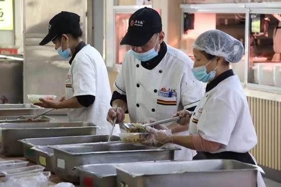 一些人在厨房里制作食物中度可信度描述已自动生成